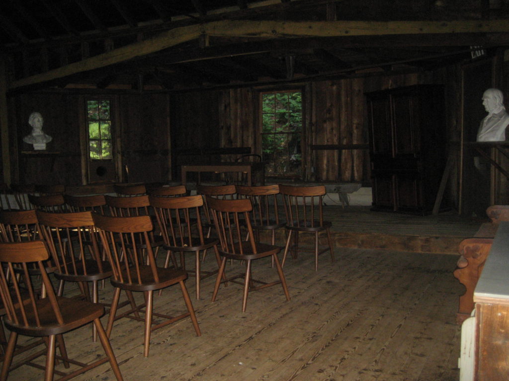 old-fashioned classroom with rows of wooden chairs